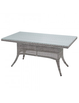 Six seater grey rattan garden table on an angle in front of stone wall