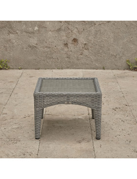 Compact garden rattan side table wirh tempered glass top pictured from the side on a southern French terrace