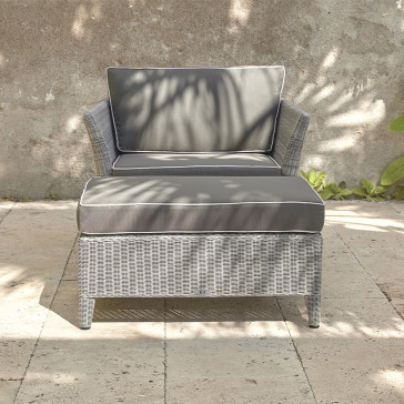 Oceane rattan garden foot stool and cushion with an armchair on a southern French terrace front view