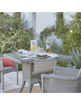 Two seater table and chairs. French Grey rattan. In a French garden.