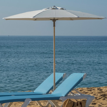 octagonal shaped parasol fully opened on french beach next to blue ocean