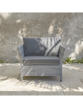 Durable and elegant garden armchair in french grey with UV resistant cushions and pale grey offset piping on a French terrace