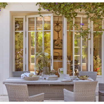 Six seater table and chairs. French Grey rattan. On a French terrace.