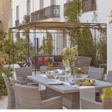 8 seater table and chairs. French Grey rattan. Corner lounge set on a French terrace.