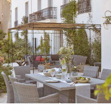 Eight seater table and chairs. French Grey rattan. On a French terrace beside corner lounge set