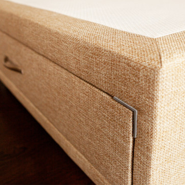 Close up image of Divan bed base with drawer upholstered in an oatmeal furniture fabric pictured on a wooden floor